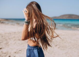 Cuidado de la piel, pelo y uñas, en verano chica en la playa con el pelo suelto en verano