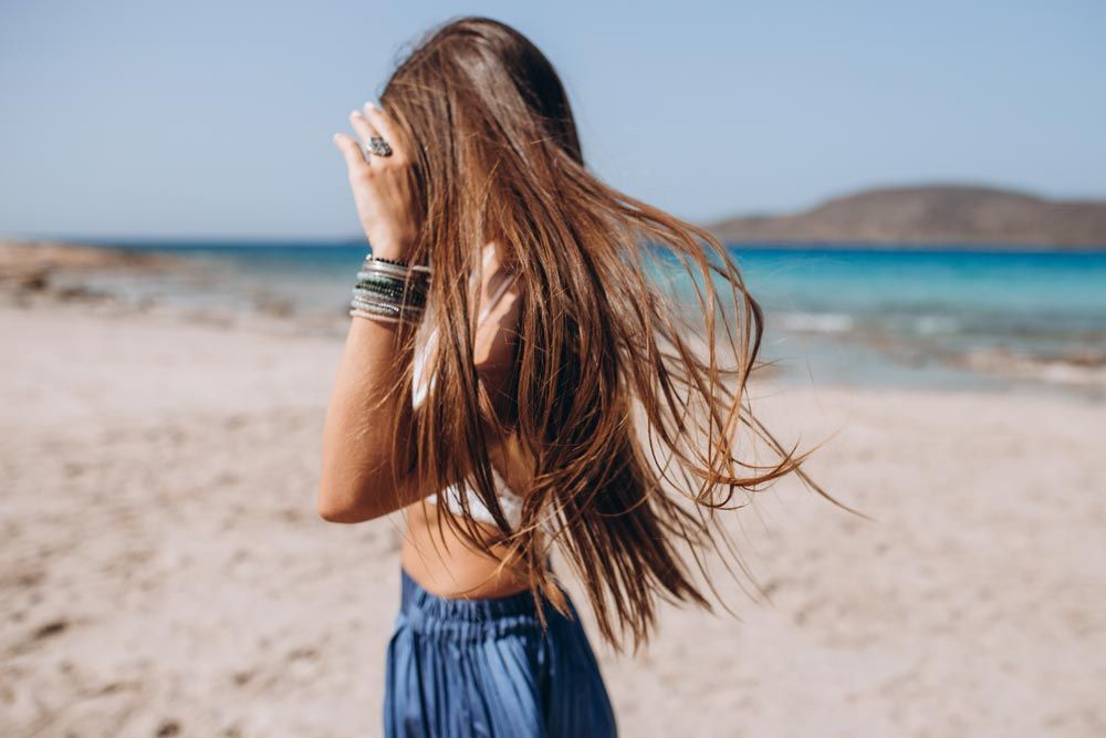 chica en la playa con el pelo suelto en verano