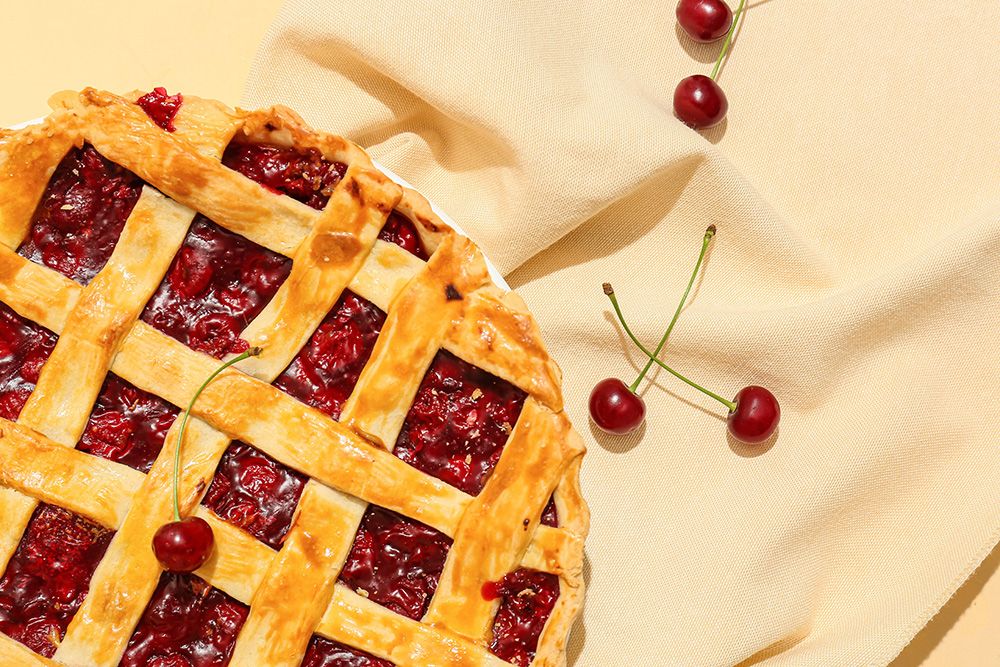 Tasty cherry pie on color background